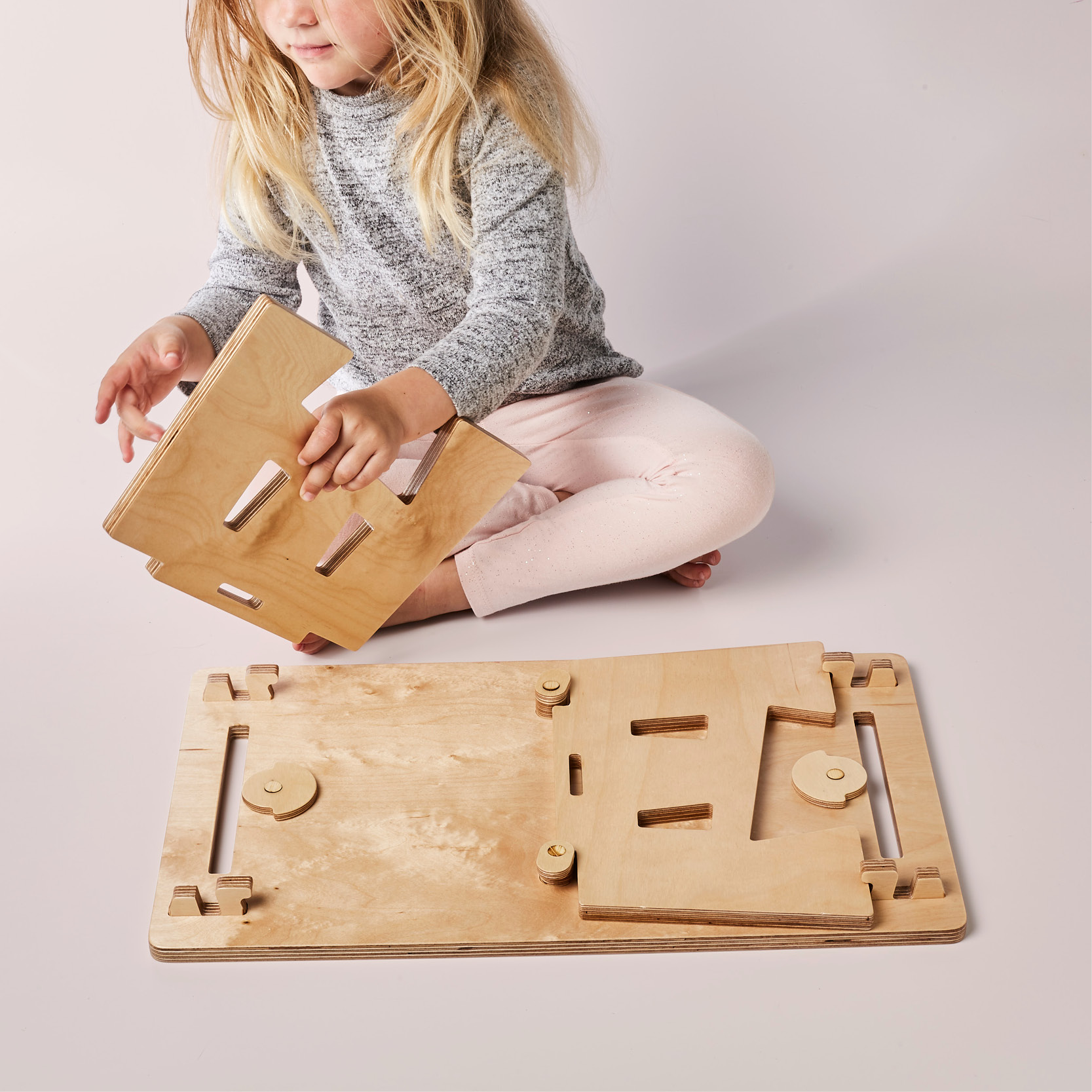 Child assembling the mydinky step while sitting down